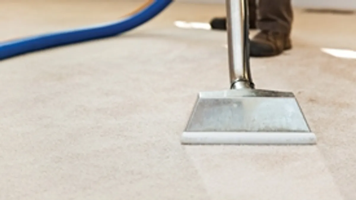 Carpet cleaning wand head gliding over a light carpet during hot-water extraction, Anchorage, AK.